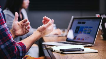 Decoratieve afbeelding van samenwerkende personen achter een laptop